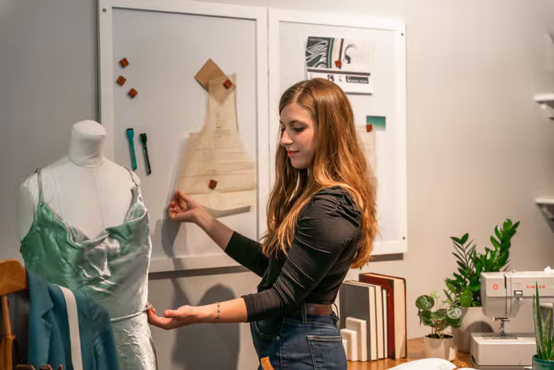 A dressmaker taking measurements in the atelier