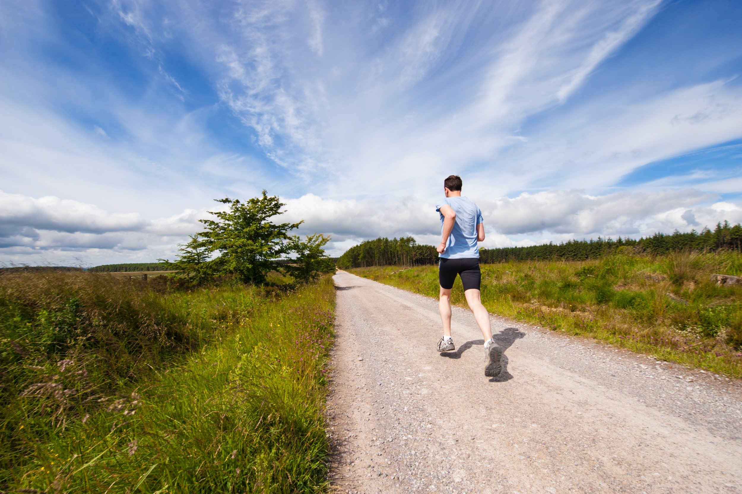 A runner running along a quiet country road