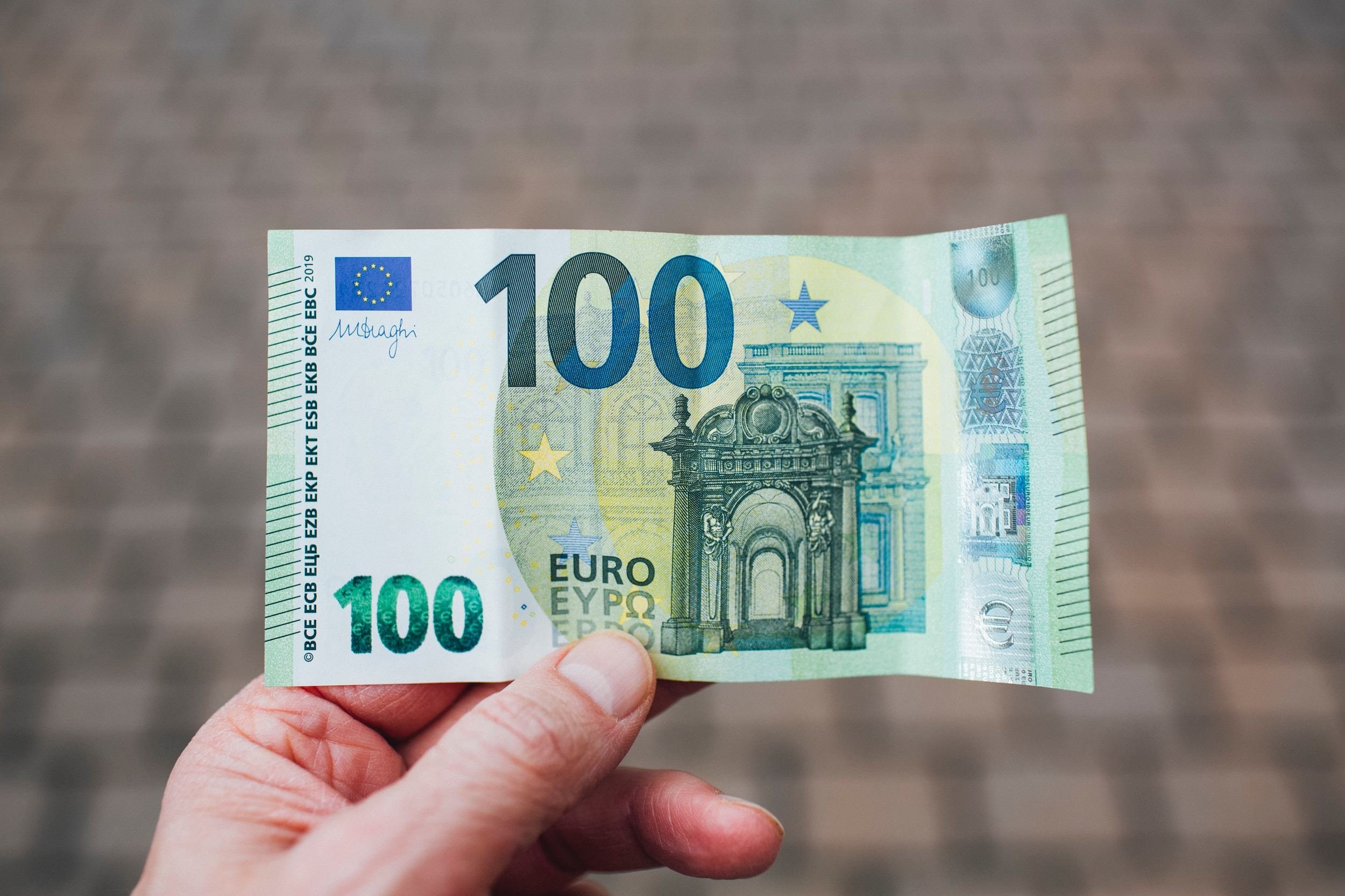Hånd som holder i en 100 euro seddel