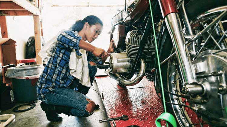 Woman working on a motorcycle in a garage