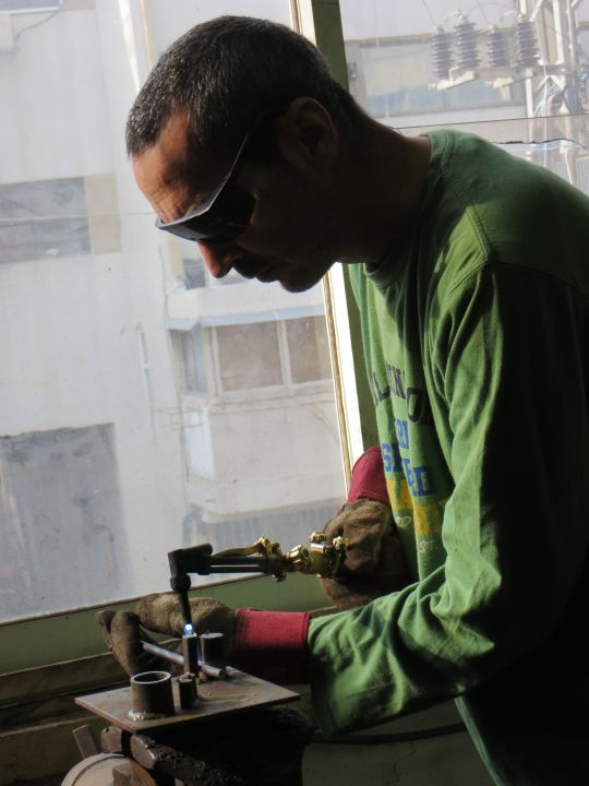 רמי אטר, פסל,  עובד בחום באמצעות מבער, אחד הכלים לנפחות מודרנית.