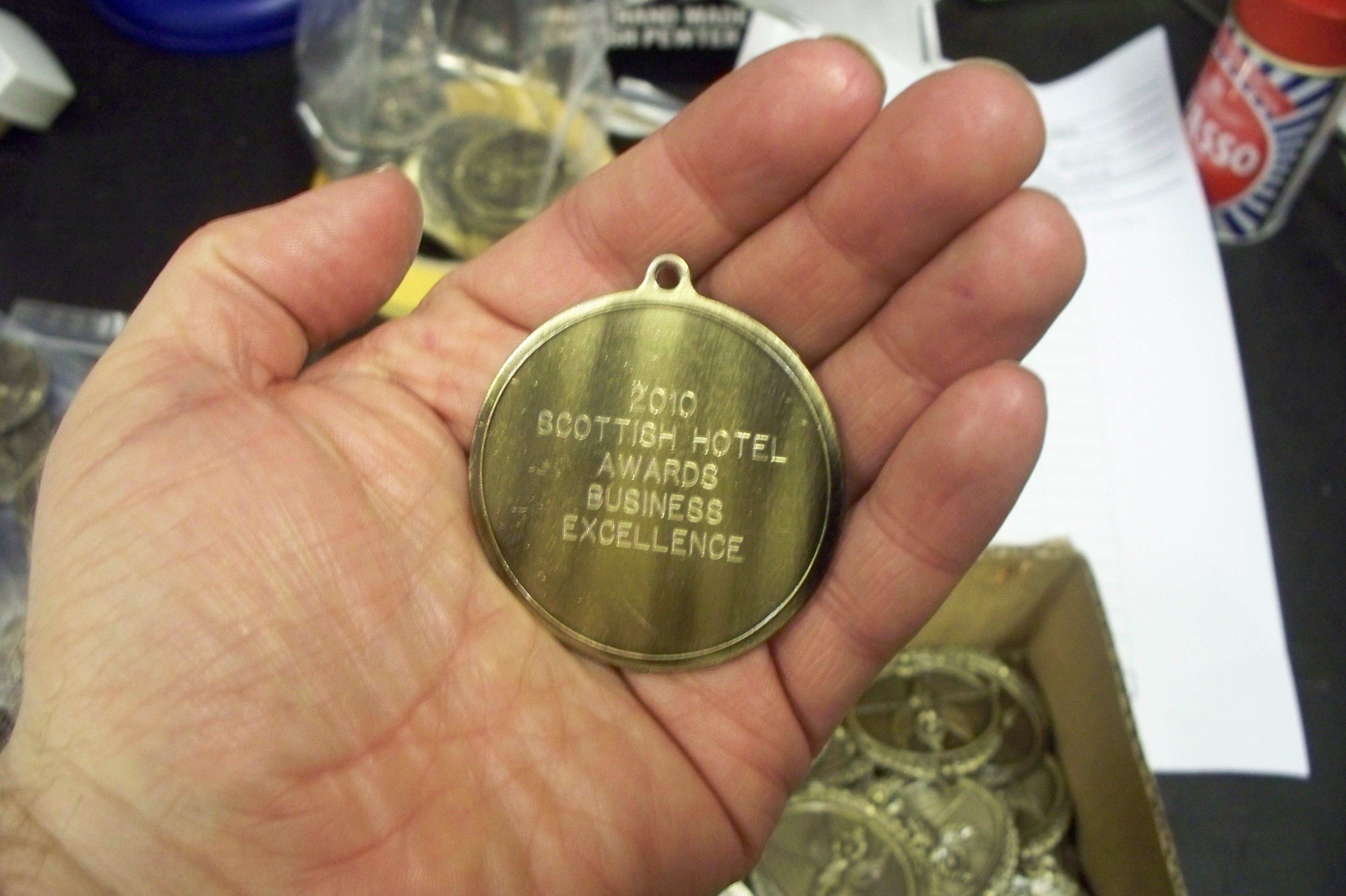an engraved medal with details of an event won held by an engraver