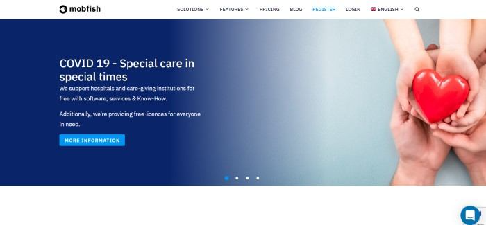 This screenshot of the home page for MobFish has a white navigation bar above a dark blue to white gradient main section, with white text on the left explaining how this company is supporting hospitals during the COVID 19 pandemic, and a child's hands holding a pink heart, lying open inside an adult's open hands on the right side of the page.