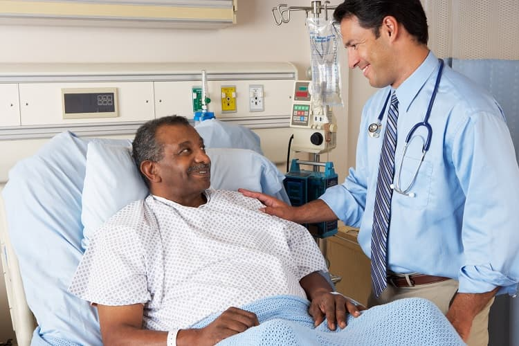 Photo of a man in a hospital talking to his doctor