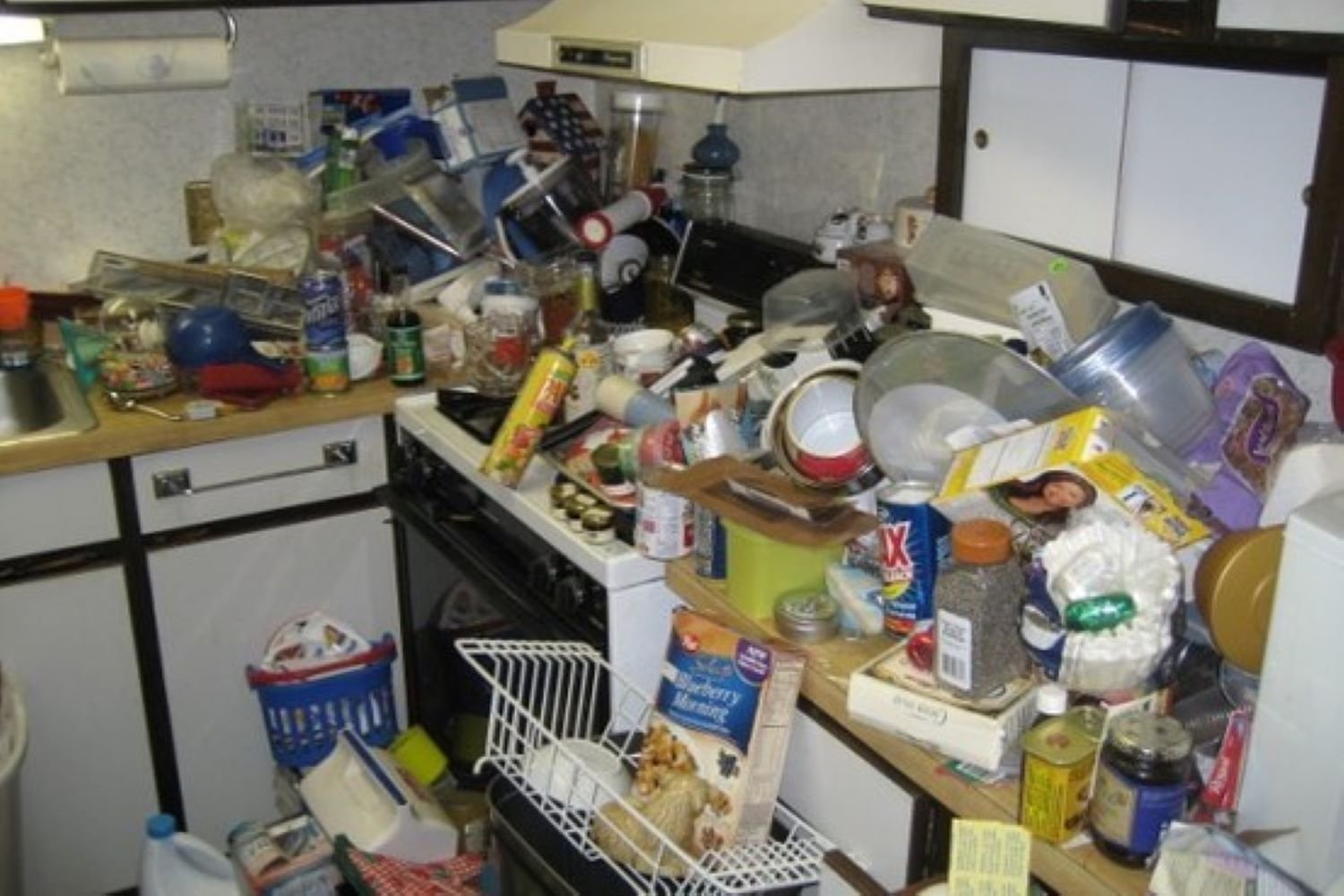 kitchen surfaces covered in junk and rubbish