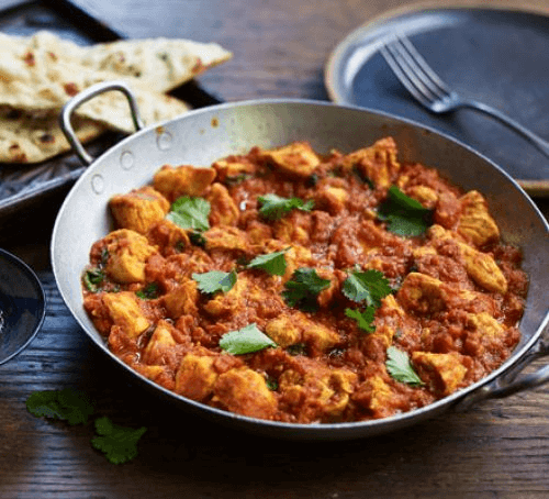 Chicken Madras curry in a balti dish with naan bread