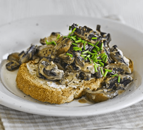 Creamy mustard mushrooms on toast with a glass of juice