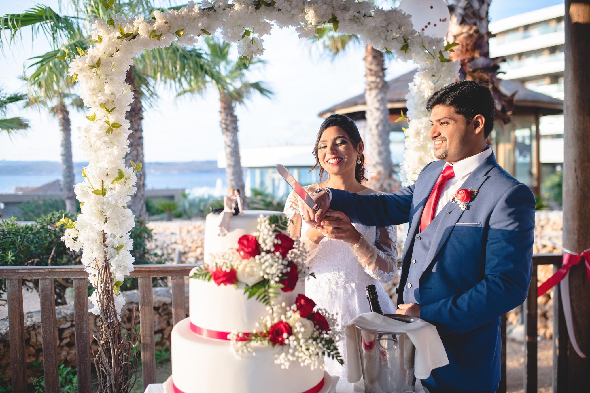 Married couple cutting wedding cake at Ramla Bay Resort