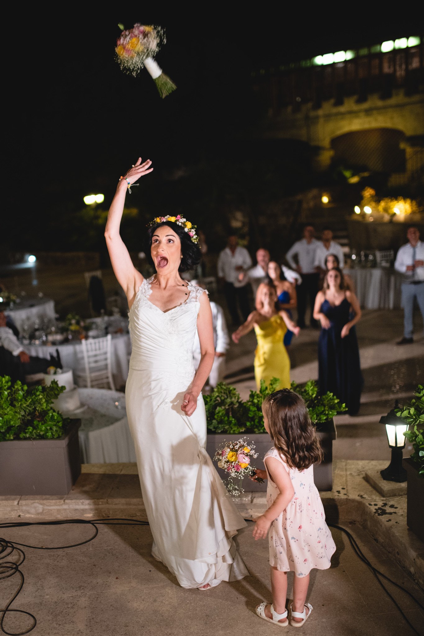 Bride throwing a wedding bouquet at Castello Zammittello in Mgarr