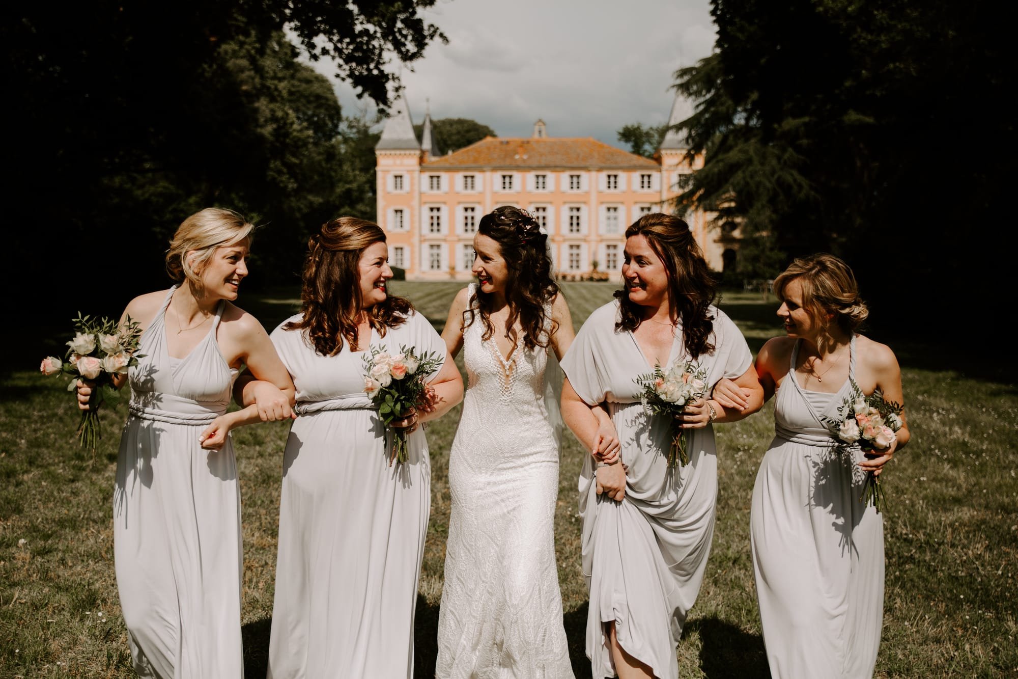 Marié et demoiselles d'honneur habillées de blanc au château de Roquelune