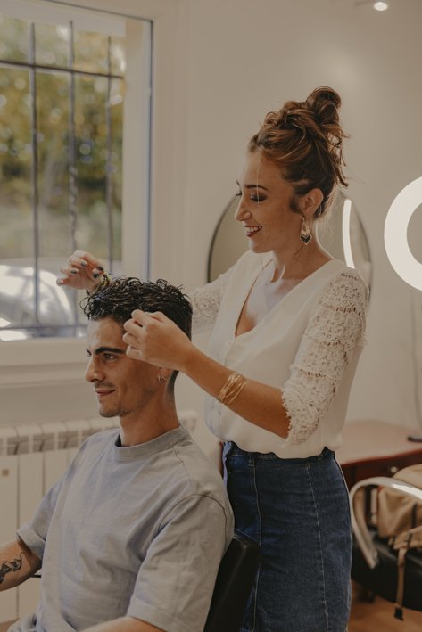 Anais Faure dans son salon de coiffure en train de réaliser une coupe homme