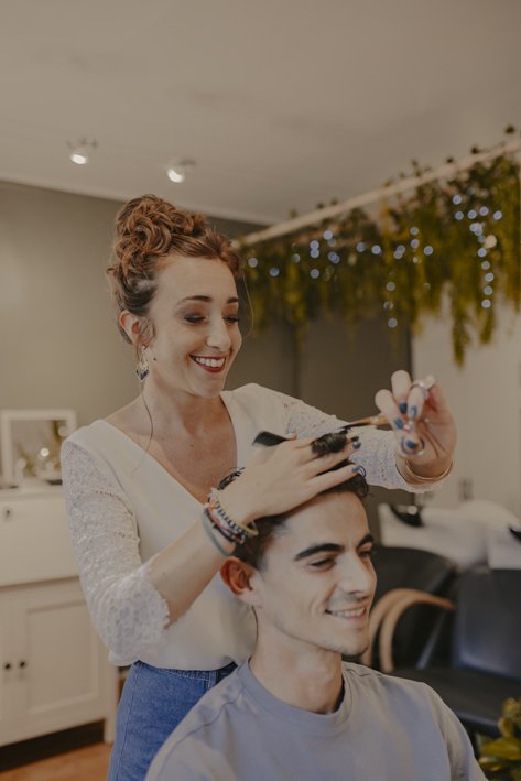 Anais Faure dans son salon de coiffure réalisant une coupe homme