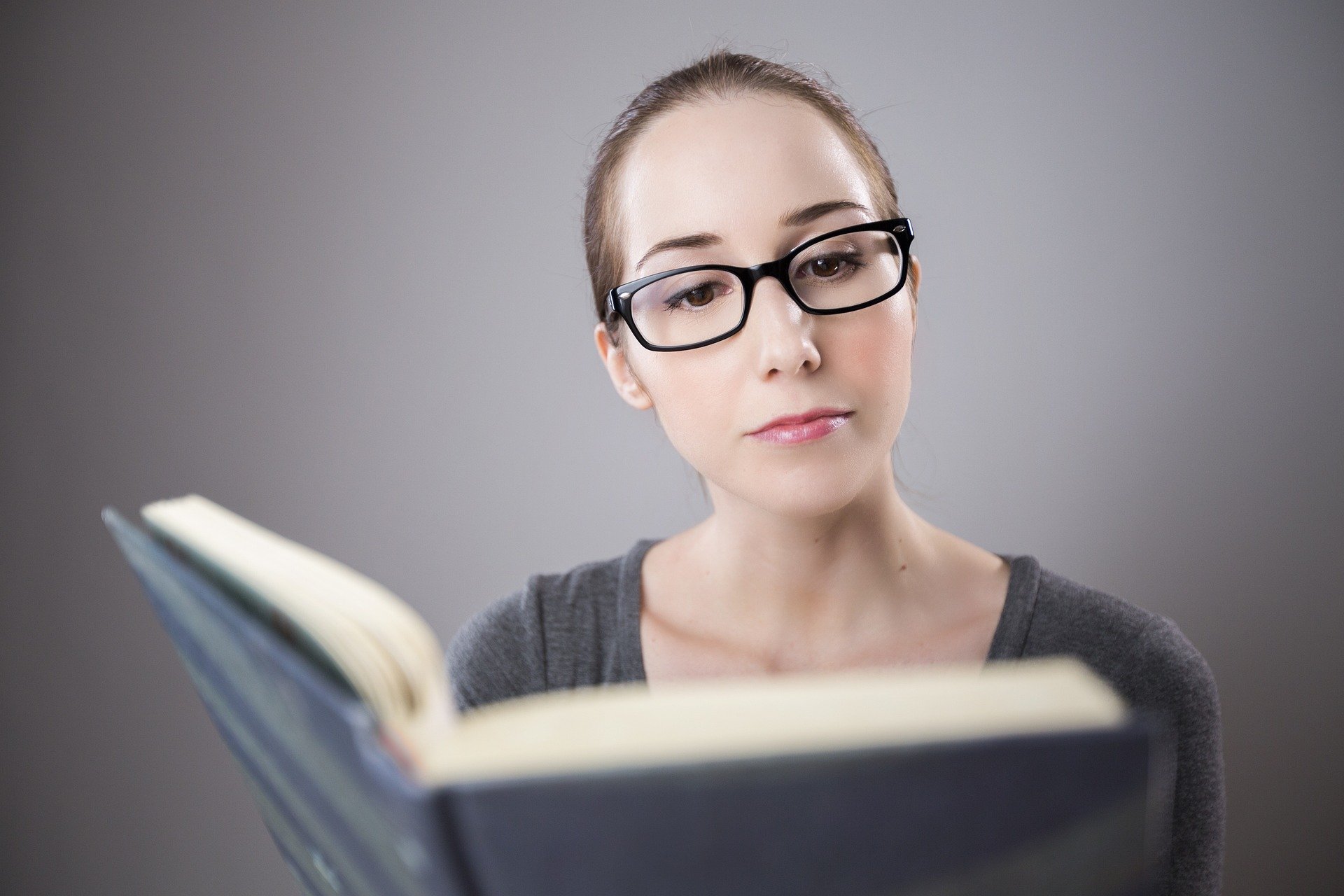 femme qui lit un livre avec lunettes