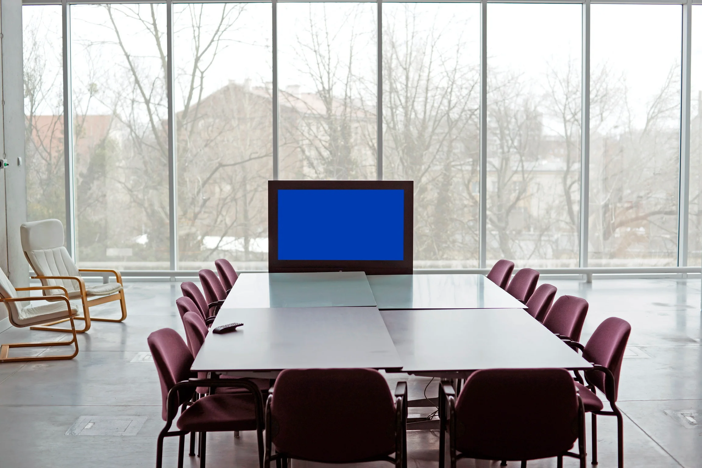 television occupies a seat at the head of a meeting room table