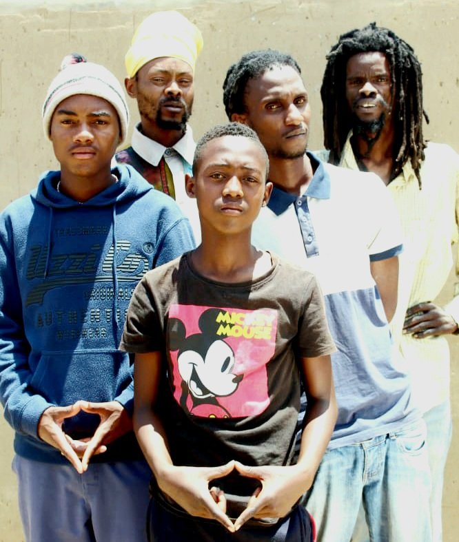 Image of the Group Jah Army Crew Posing for a photo with a trinity sign