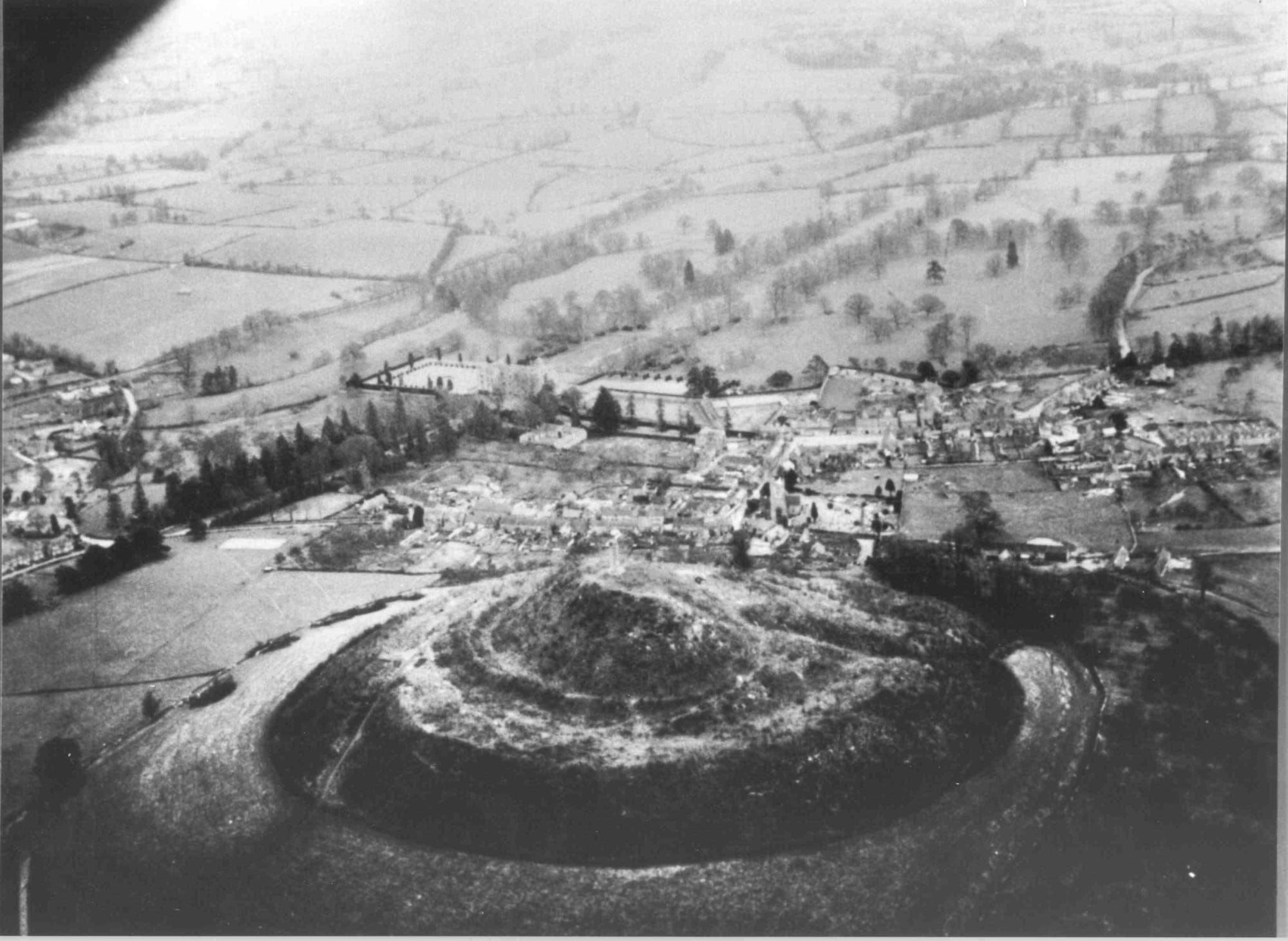black and white photo taken from above Hedgecock Hill looking north-east across St Michael's Hill in the foreground and Montacute village and house in the background. The hill appears to have been recently cleared of all trees and shrubs