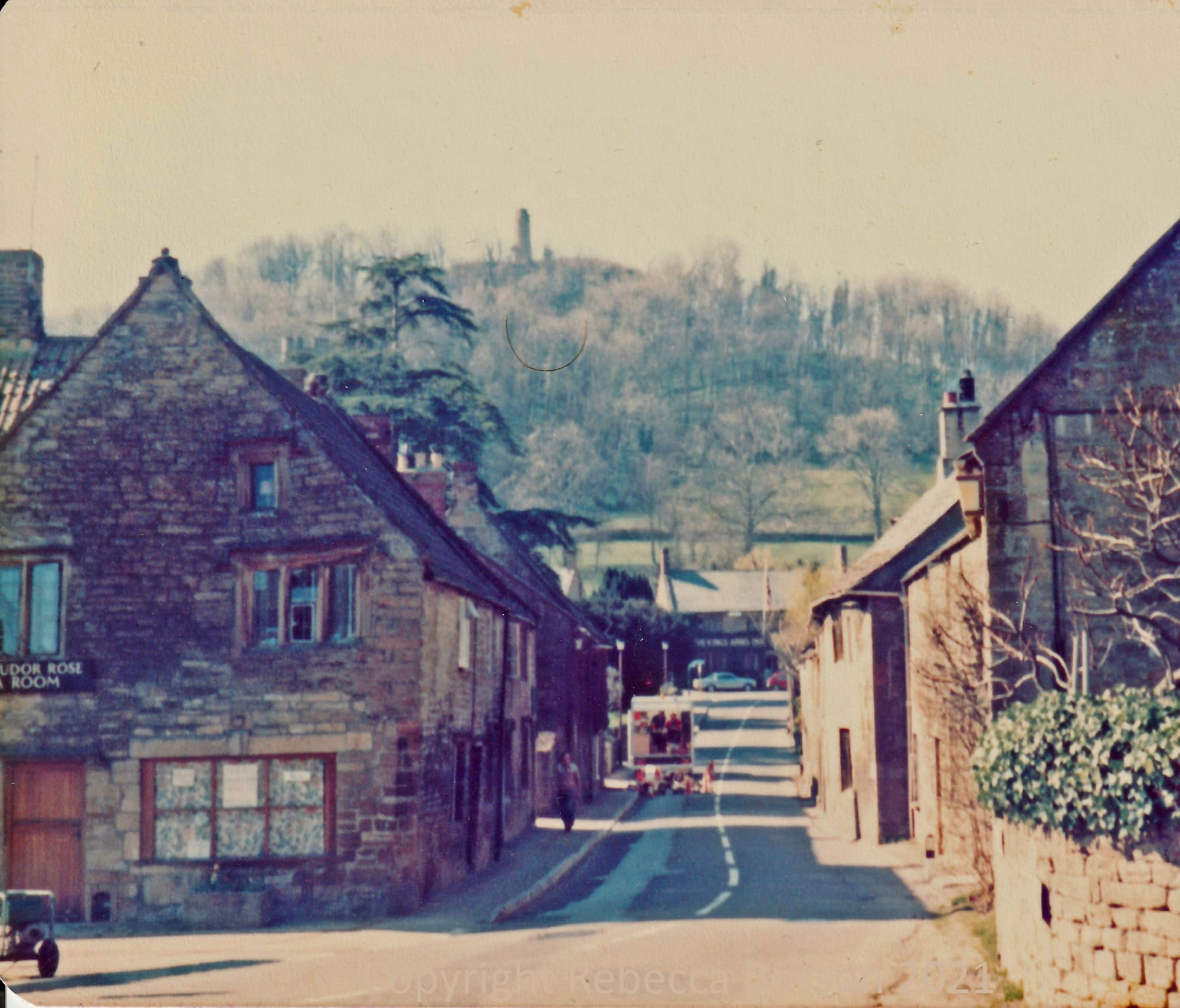 colour photo taken from the Borough entrance to Montacute House looking up middle street to the tower with 'Tudor Rose Tea Room' sign on the building on the corner of middle street and the Borough