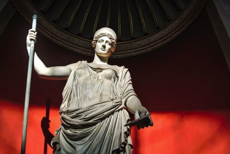 White marble statue of a classic majestic goddess holding a staff in a palatial setting resembling the topic of the article Destiny in Philosophy