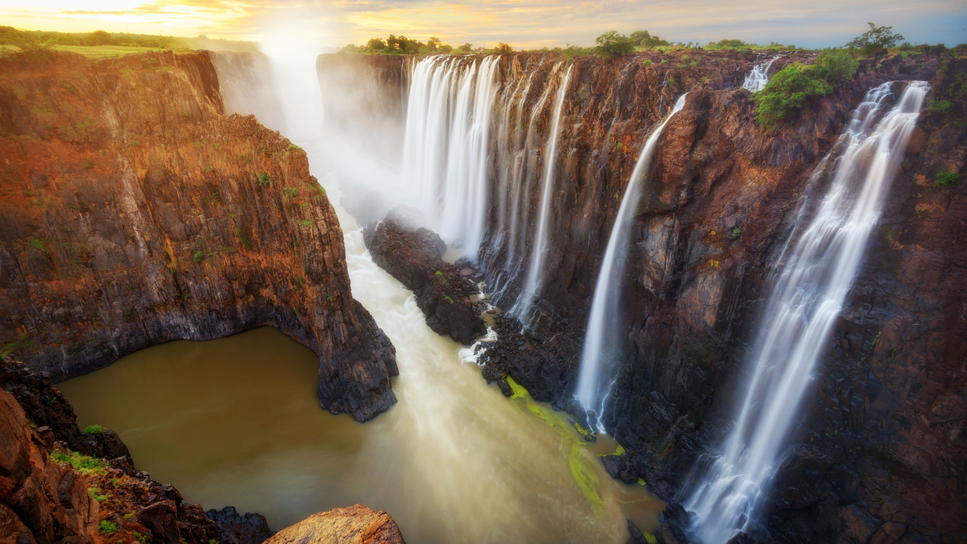 Victoria Falls, located on the border of Zambia and Zimbabwe, is one of the world's most awe-inspiring natural wonders. Feel the mist on your face and be captivated by the thunderous roar of the Falls as millions of gallons of water cascade down the cliffs. Admire the breathtaking beauty, go on a thrilling white-water rafting adventure, or take a scenic helicopter ride for a panoramic view of this mesmerizing spectacle.