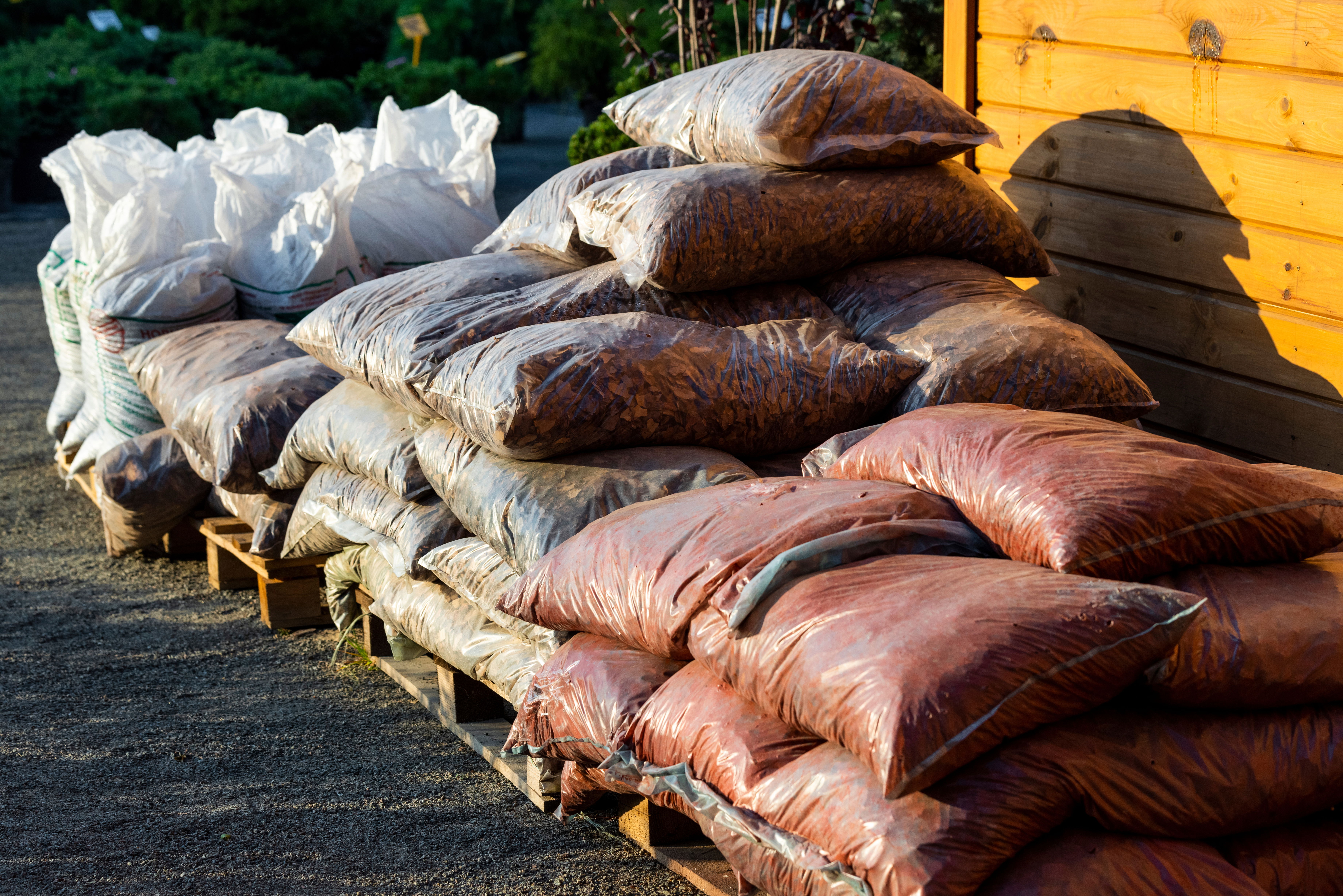 Several bags of tree mulch sitting on a pallet 