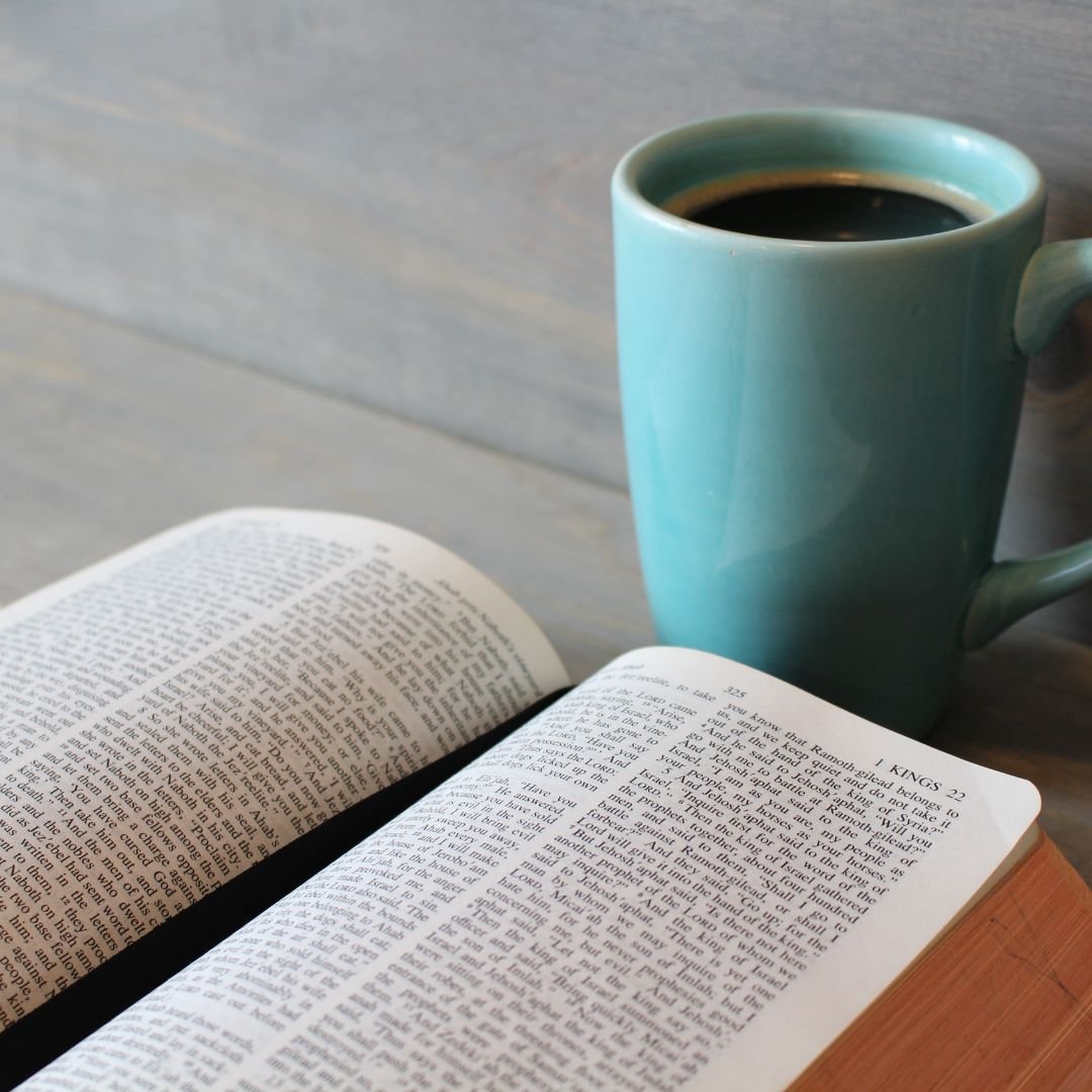 Open Bible with a cup of coffee next to it