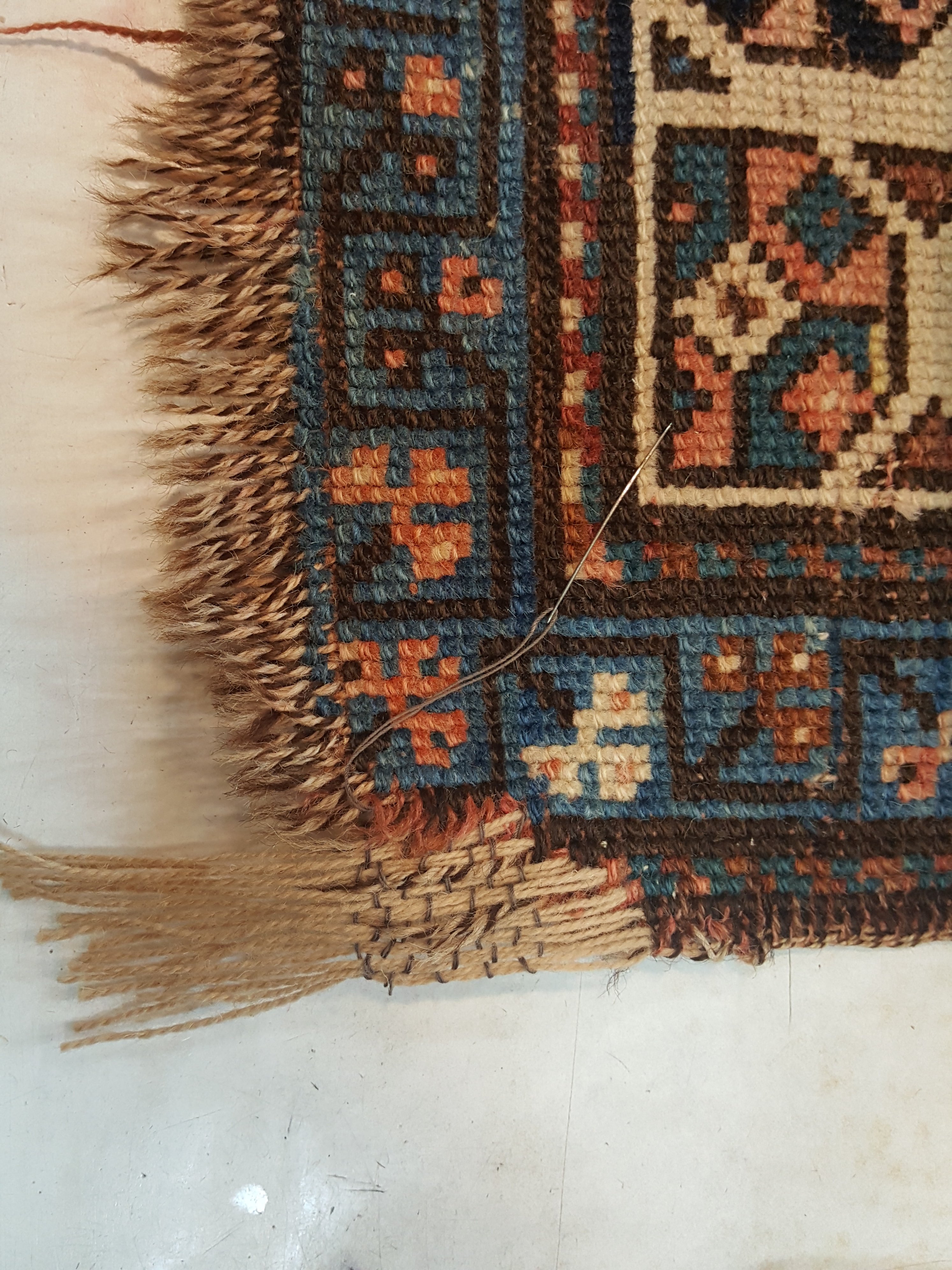 שטיח קווקזי עתיק שחוק בפינה