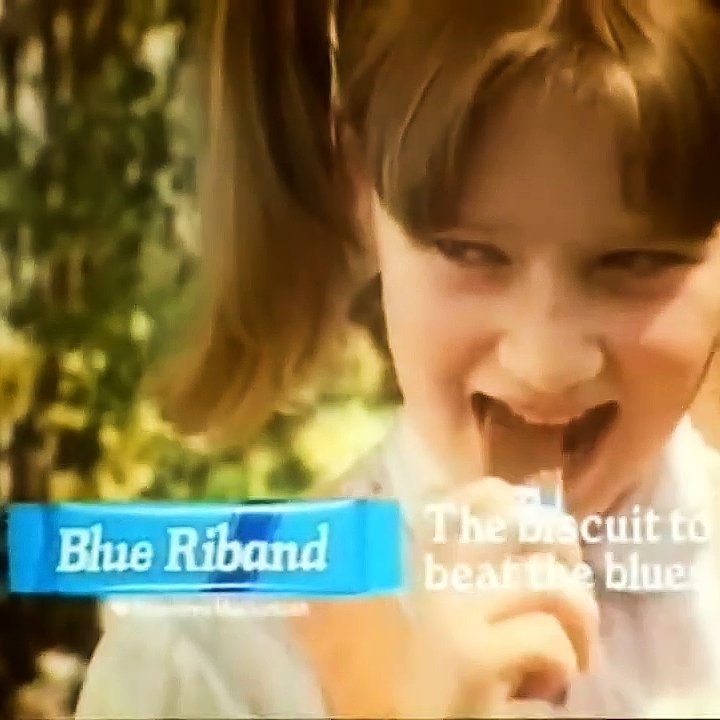 Girl eating a Blue Riband chocolate biscuit in 1985