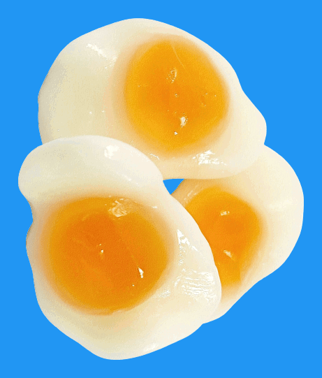 Close up of three fried egg sweets with deep blue background