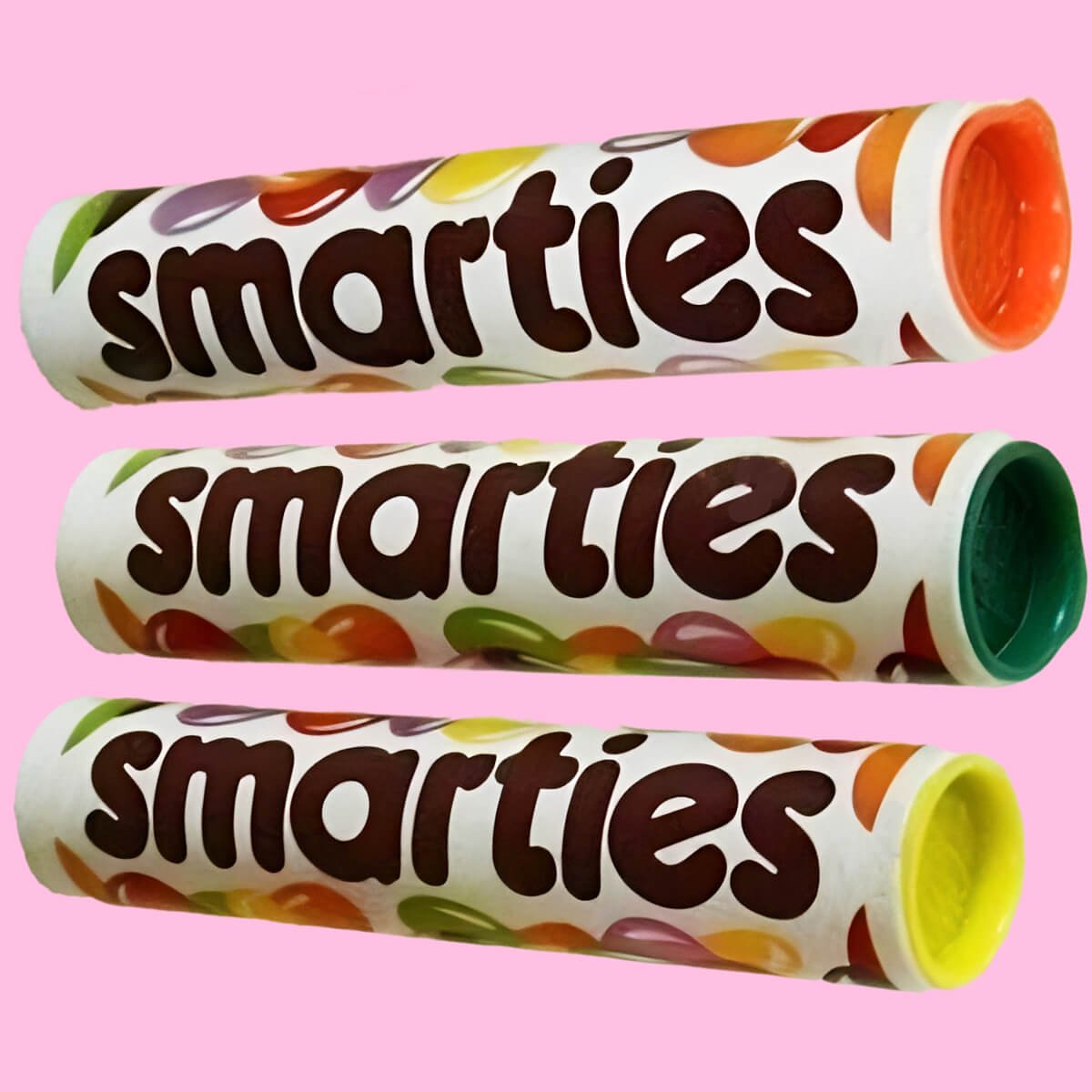Three tubes of Smarties from the 1980s with orange, green and yellow caps