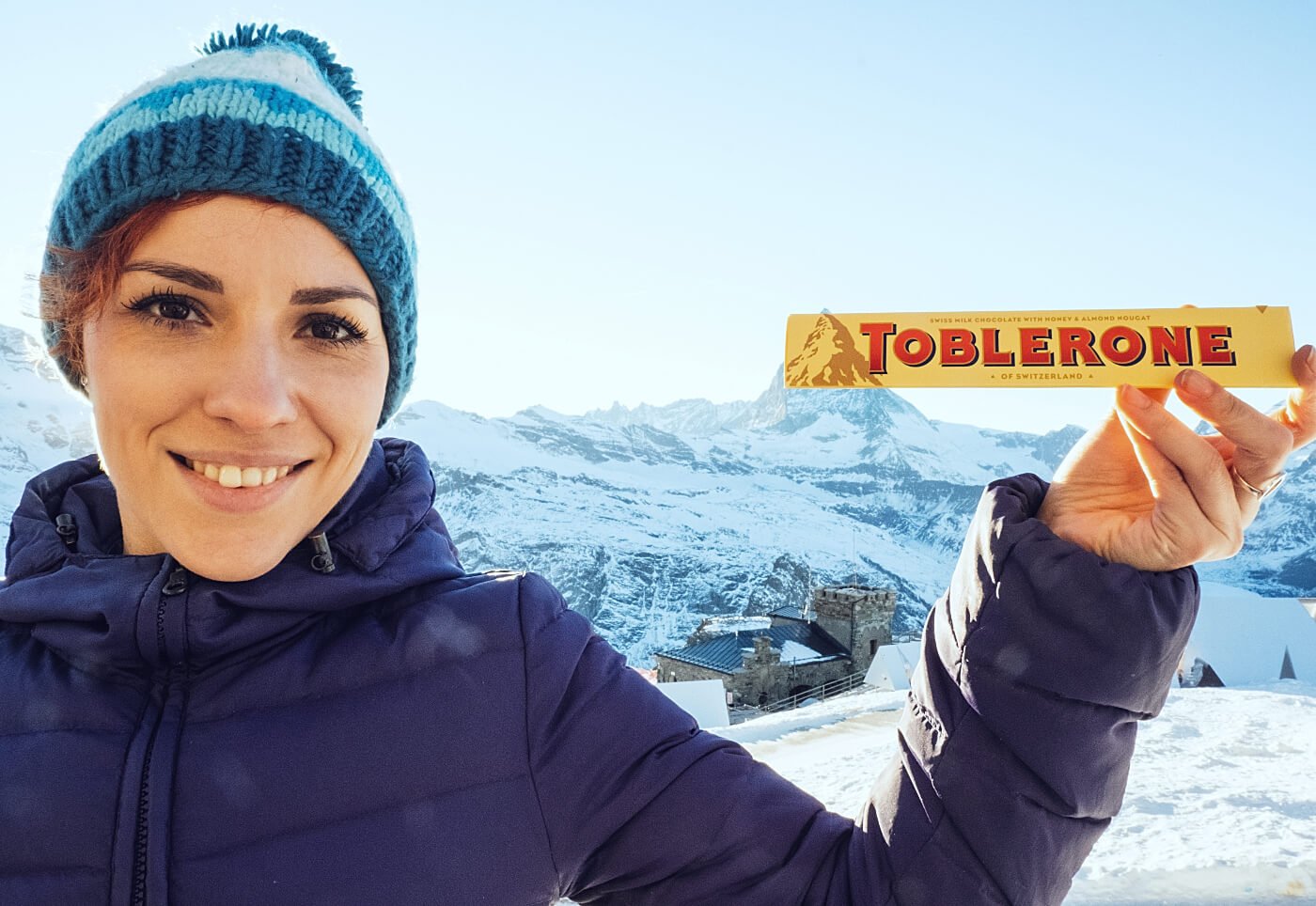 Woman holding a Toblerone in front of the Matterhorn