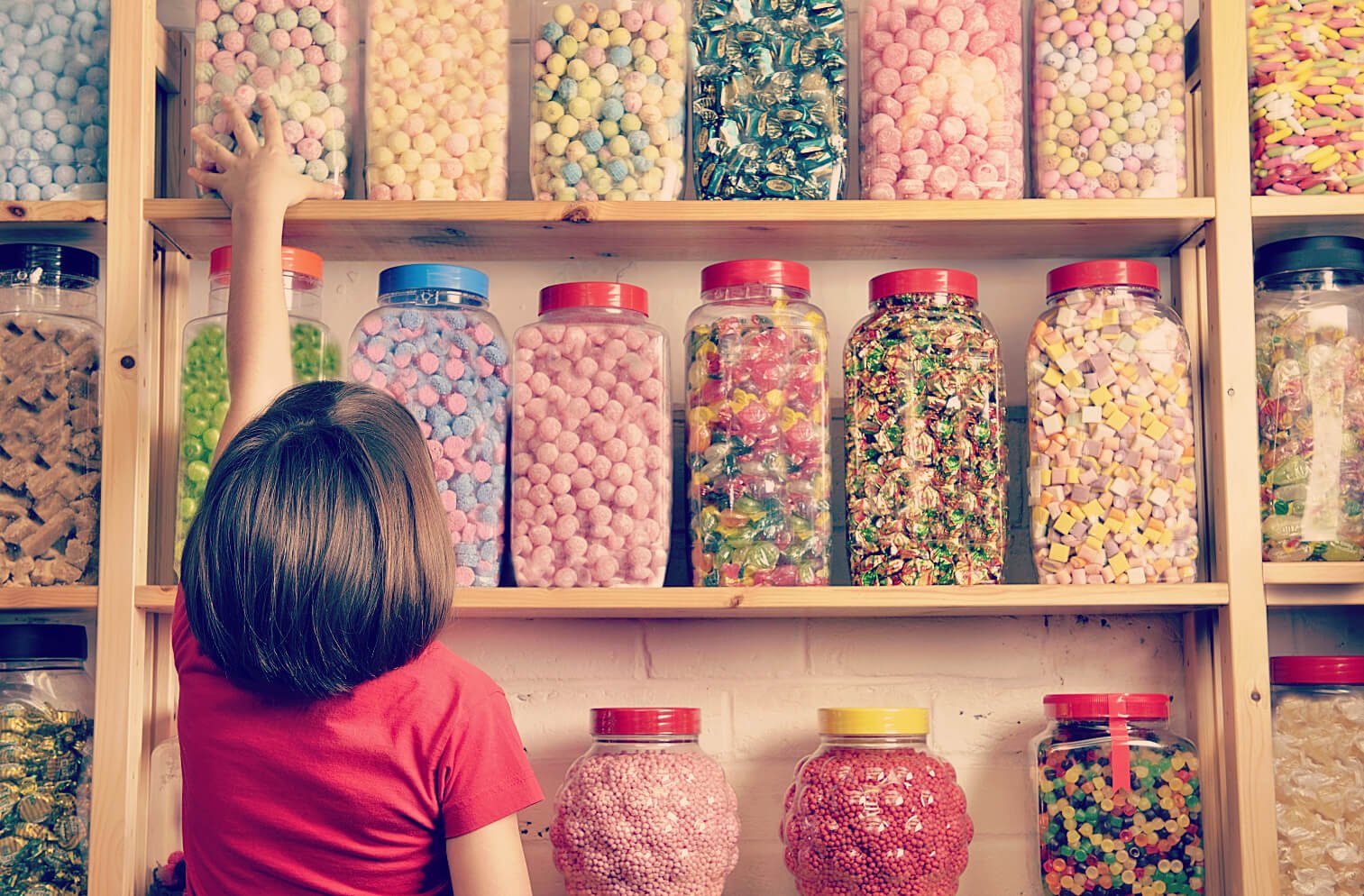 Young girl with jars of sweets in a 1980s sweet shop