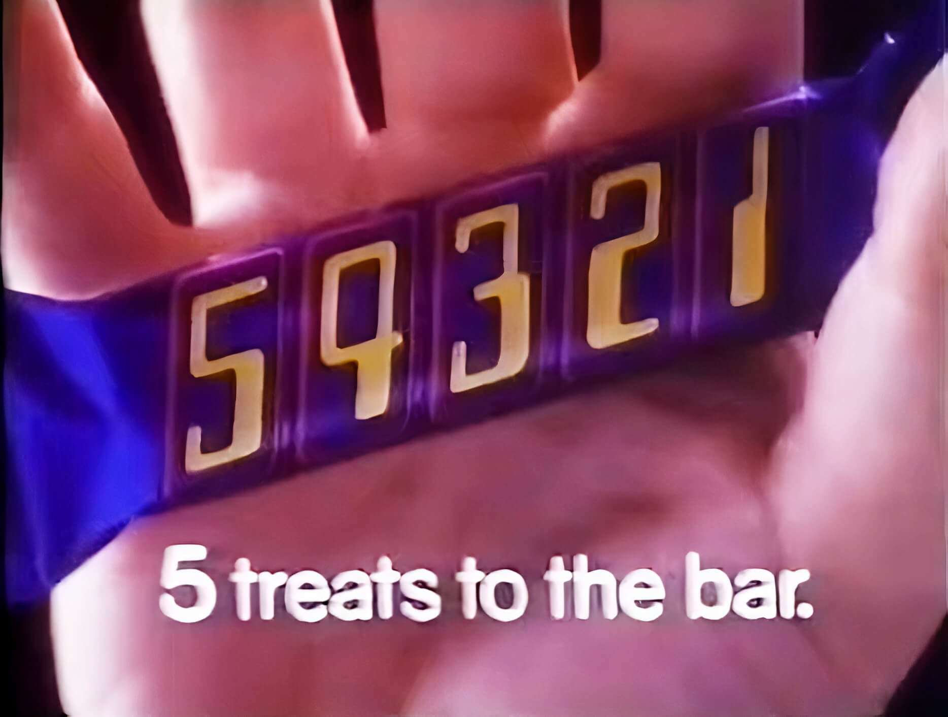 Original 54321 chocolate bar in a person's hand (1982) with tagline 5 treats to the bar.