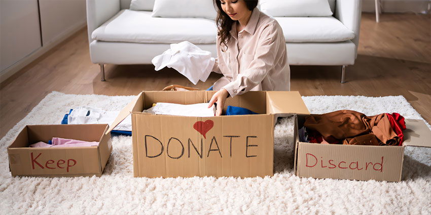 Woman Sorting Items to Donate, Discard, Keep Boxes
